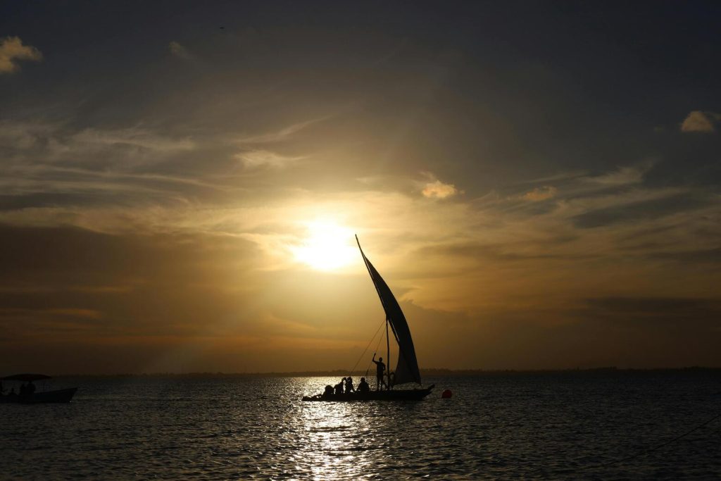 Lamu Festival Season 2025 — traditional dhow sailing at sunset on the Swahili coast.