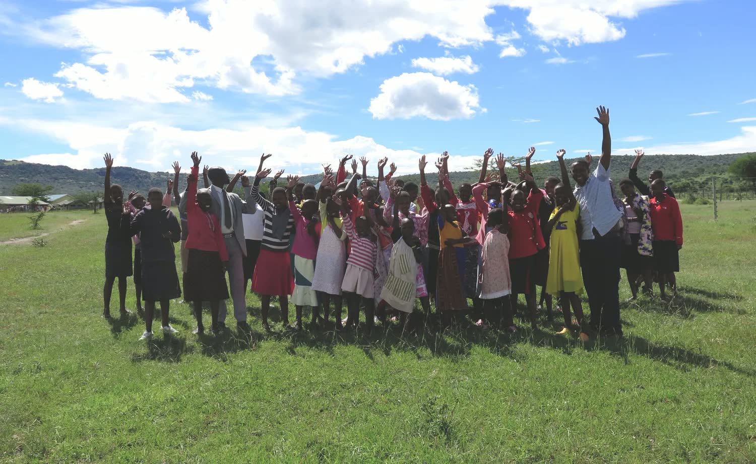 Girls raising hands at the Entumoto Rescue Centre, Mara Siana Conservancy, Kenya