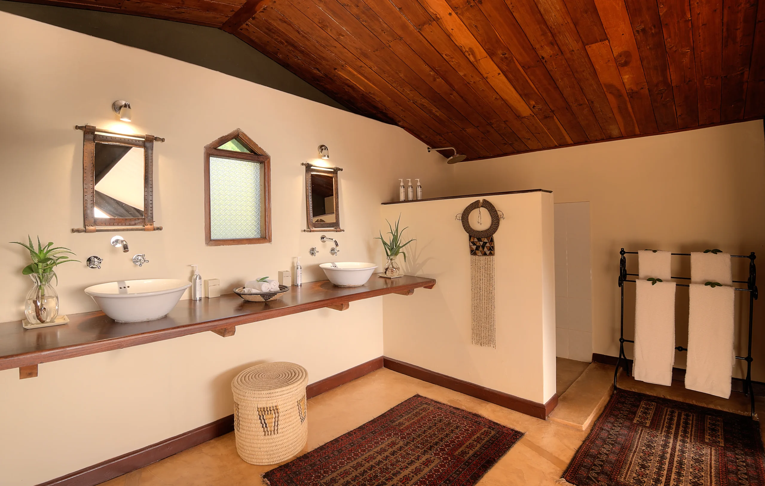 En-suite bathroom with wood-beamed ceiling and double sinks, Entumoto Safari Camp. Photo: Vanessa Knight