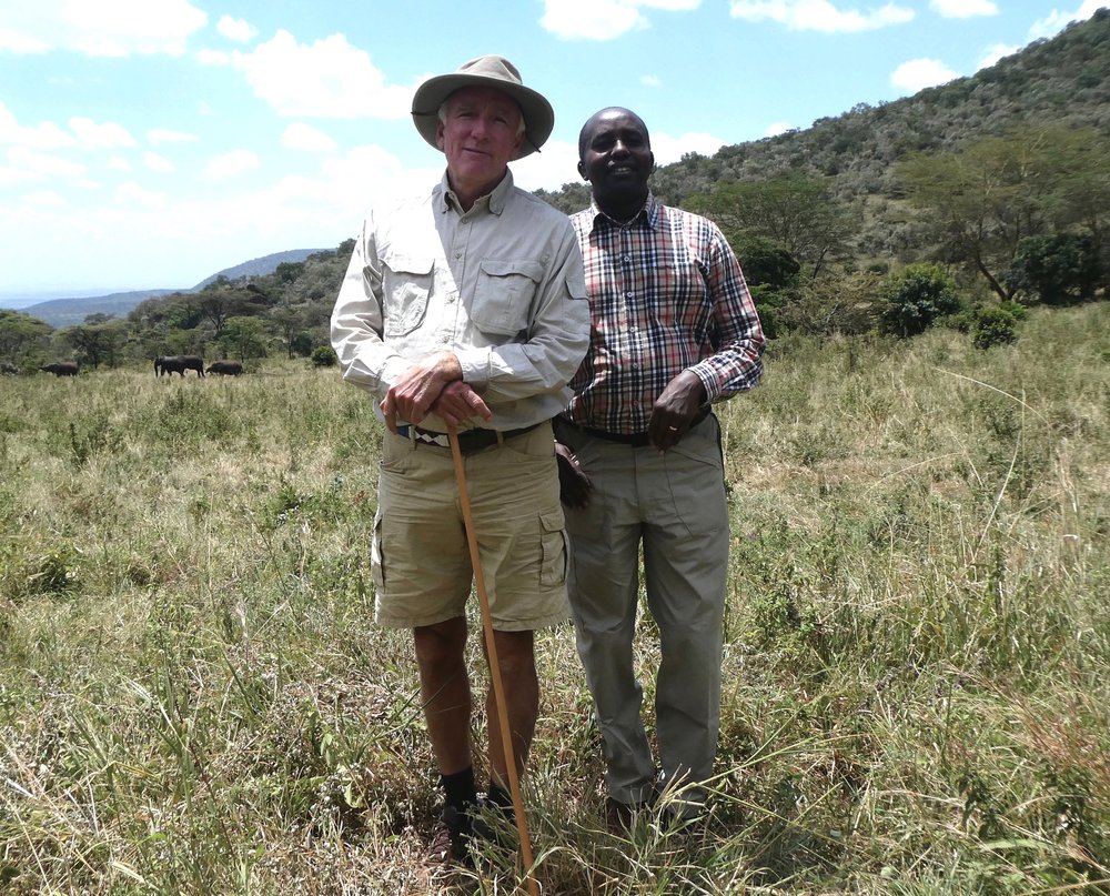 Karl von Heland and Rimoine Ole Kararei standing in the Mara Siana Conservancy with elephants in the background